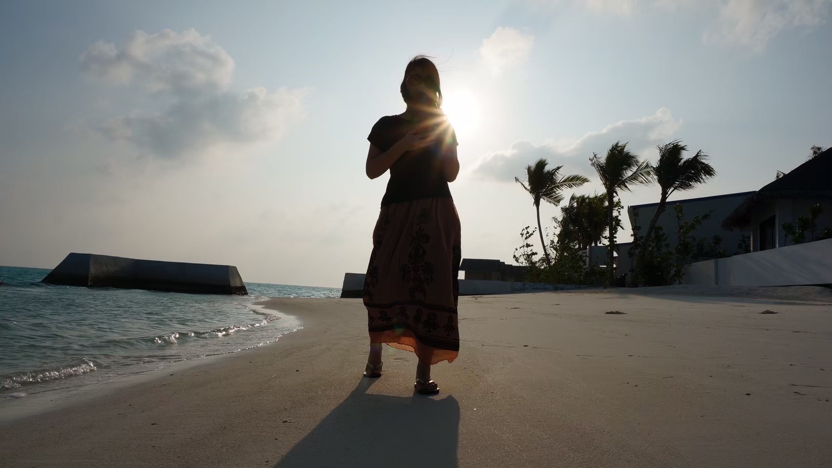 夕方の浜辺に立つ人